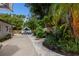 A view of the backyard showing RV parking on a concrete slab, and a garden with tropical plants and landscaping at 671 47Th St, Sarasota, FL 34234