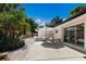 Landscaped backyard with white stone, an umbrella shaded table, seating area, and sliding glass doors at 671 47Th St, Sarasota, FL 34234