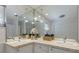 Bright bathroom with double sink, tiled countertop, and a large mirror reflecting pendant lighting and decor at 671 47Th St, Sarasota, FL 34234