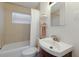 Bathroom features neutral tile, a shower-tub combo, dark-wood vanity, and a large rounded sink basin at 671 47Th St, Sarasota, FL 34234
