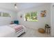 Bright bedroom featuring a cozy bed with striped blanket, chair, neutral rug, and a window view at 671 47Th St, Sarasota, FL 34234