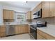 Modern kitchen with stainless steel appliances, blonde cabinets, stone countertops, and a window view at 671 47Th St, Sarasota, FL 34234