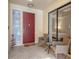 Inviting front porch with red door, wicker chairs, and glass door offering a view inside at 7242 Villa D Este Dr, Sarasota, FL 34238