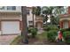 Exterior view of townhouse with landscaping, walkway, and garage at 7307 Fountain Palm Cir # 7-102, Bradenton, FL 34203