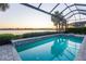 Relaxing screened pool and spa with lake view at sunset at 788 Sigsbee Loop, Sarasota, FL 34240