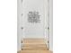 Hallway features light hardwood floors, white walls, and modern artwork at 8367 Sea Glass Ct, Sarasota, FL 34240