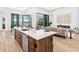 Spacious kitchen island with stone countertop and modern sink overlooking the outdoor living area at 8367 Sea Glass Ct, Sarasota, FL 34240