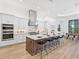 Modern kitchen with stainless steel appliances, island with seating, and stylish lighting at 8367 Sea Glass Ct, Sarasota, FL 34240