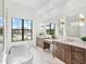 Luxurious main bathroom with double vanities, a soaking tub, and marble flooring at 8367 Sea Glass Ct, Sarasota, FL 34240