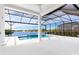 Picturesque pool area with a spa, surrounded by a screened enclosure and tranquil lake views at 8367 Sea Glass Ct, Sarasota, FL 34240