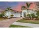 Two-story home with light blue exterior, palm trees, and a paved driveway at 8532 Pavia Way, Lakewood Ranch, FL 34202