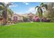 One-story home with landscaped yard, palm trees, and a large lawn at 22435 Panther Loop, Bradenton, FL 34202