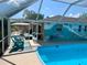 Screened in pool with painted mural wall, outdoor seating, and lush landscaping at 2426 Nassau St, Sarasota, FL 34231