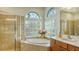 Spa-like bathroom with soaking tub, double sinks, and a glass block window at 2886 Grazeland Dr, Sarasota, FL 34240