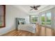 Bright bedroom with hard wood flooring, large window with backyard view and ceiling fan at 2886 Grazeland Dr, Sarasota, FL 34240