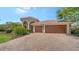Paver driveway leading to a three-car garage and inviting entrance at 2886 Grazeland Dr, Sarasota, FL 34240