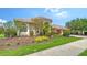 Beautiful exterior with a paver driveway, lush landscaping, and a tile roof at 2886 Grazeland Dr, Sarasota, FL 34240