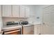 Well-equipped laundry room with modern washer and dryer, ample cabinet space, and a convenient utility sink at 2886 Grazeland Dr, Sarasota, FL 34240