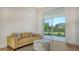 Cozy living room with tile flooring, large windows with backyard view and a comfortable sofa at 2886 Grazeland Dr, Sarasota, FL 34240