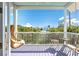 Peaceful balcony with a wicker swing chair and outdoor seating at 307 Spring Ave, Anna Maria, FL 34216