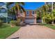 Two-story house with a brick driveway and palm trees at 312 61St St # B, Holmes Beach, FL 34217