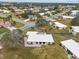 Aerial view showcasing the neighborhood, palm trees, and the white-roofed homes below at 430 Botticelli Dr # 430, Nokomis, FL 34275