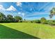 Expansive, lush backyard with manicured lawn and tropical landscaping offers serene outdoor space at 506 S Casey Key Rd, Nokomis, FL 34275