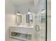 Bright bathroom featuring double vanity, open shelving, and stylish lighting fixtures at 506 S Casey Key Rd, Nokomis, FL 34275