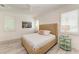 Bright bedroom with a woven bed frame, ceiling fan, shutters and coastal decor at 506 S Casey Key Rd, Nokomis, FL 34275