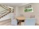 Cozy dining area with round table, striped chairs, and staircase nearby at 506 S Casey Key Rd, Nokomis, FL 34275