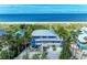 Aerial view of the luxury beachfront home featuring multiple balconies, lush landscaping, and a serene ocean backdrop at 506 S Casey Key Rd, Nokomis, FL 34275
