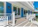 Gorgeous blue home featuring white trim, glass doors, and a charming covered porch at 506 S Casey Key Rd, Nokomis, FL 34275