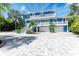 Beautiful blue two-story home featuring balconies, a three car garage and a stylish paved driveway at 506 S Casey Key Rd, Nokomis, FL 34275