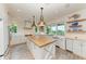 Modern kitchen with white cabinets, a large island with wood countertop at 506 S Casey Key Rd, Nokomis, FL 34275