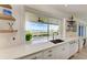Gourmet kitchen with luxurious countertops, pass-through window, and scenic outdoor views at 506 S Casey Key Rd, Nokomis, FL 34275