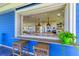 Outdoor counter pass-through into a spacious kitchen with modern appliances and white cabinetry at 506 S Casey Key Rd, Nokomis, FL 34275