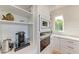 White kitchen with built-in wall oven, microwave and coffee maker at 506 S Casey Key Rd, Nokomis, FL 34275