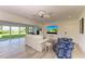 Bright living room with white sofas, ceiling fan, and sliding glass doors to the yard at 506 S Casey Key Rd, Nokomis, FL 34275