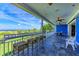 Spacious covered outdoor patio with beautiful stone flooring, seating, ceiling fans, and ocean views at 506 S Casey Key Rd, Nokomis, FL 34275