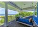 Inviting porch with daybed swing overlooking ocean views and sandy beach at 506 S Casey Key Rd, Nokomis, FL 34275