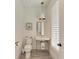 Charming powder room featuring vintage-style fixtures, a pendant light, and a window with shutters at 506 S Casey Key Rd, Nokomis, FL 34275