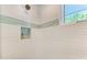 Shower with textured white tile, recessed shelving, and a window at 506 S Casey Key Rd, Nokomis, FL 34275