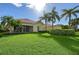 Large backyard with lush lawn and tropical plants at 5759 Benevento Dr, Sarasota, FL 34238