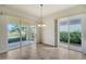 Bright dining room with sliders opening to a patio and lush greenery at 5759 Benevento Dr, Sarasota, FL 34238