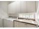 Laundry room with white cabinets, washer, dryer, and sink at 5759 Benevento Dr, Sarasota, FL 34238
