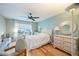 Bedroom with hardwood floors, white bedding, and ceiling fan at 612 Foxwood Blvd # 612, Englewood, FL 34223