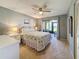 Bedroom with floral bedding, ceiling fan, and sliding glass door to patio at 707 Sorrento Inlt # 707, Nokomis, FL 34275