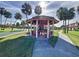 Relaxing gazebo with seating, surrounded by palm trees and shuffleboard courts at 707 Sorrento Inlt # 707, Nokomis, FL 34275