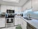 Bright kitchen, stainless steel appliances, white cabinets, and light countertops at 707 Sorrento Inlt # 707, Nokomis, FL 34275