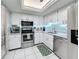 Modern kitchen with stainless steel appliances, white cabinets, and light-blue backsplash at 707 Sorrento Inlt # 707, Nokomis, FL 34275